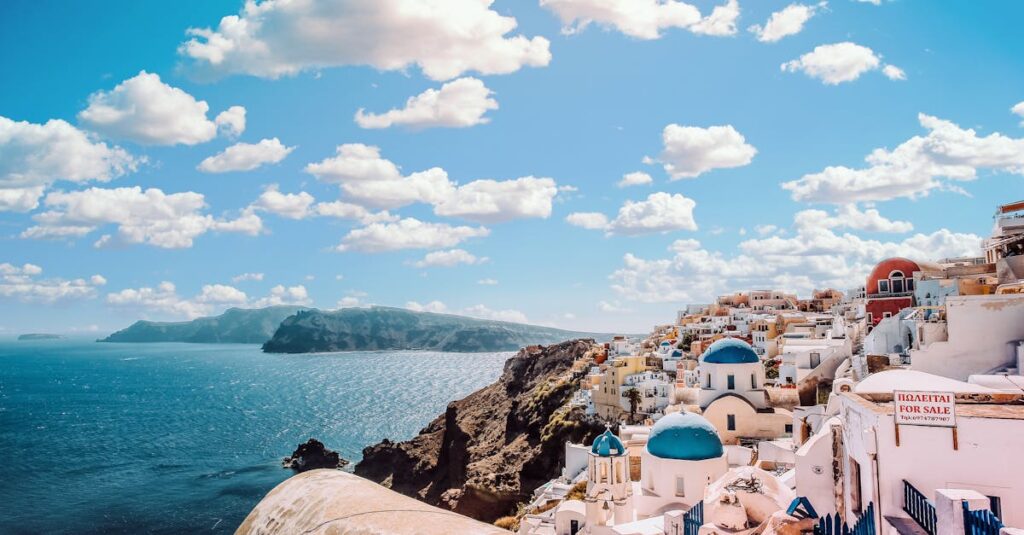 White Concrete House Near Body of Water Under White and Blue Cloudy Sky. Book flights and hotels